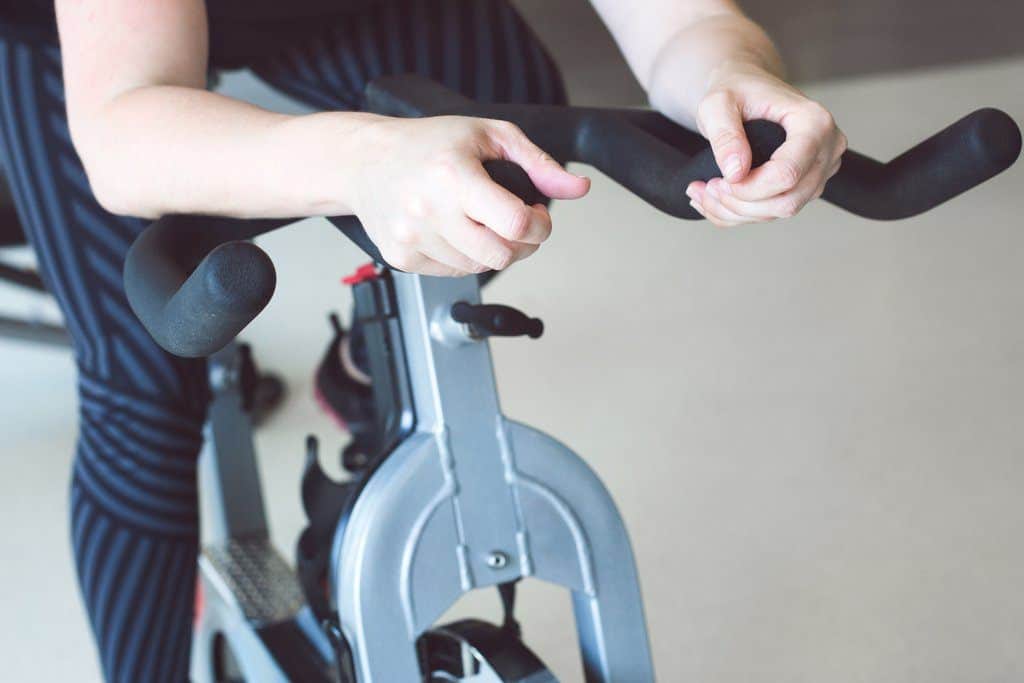 Home Gym Bike Workout Women rides a spinning bike in her home gym