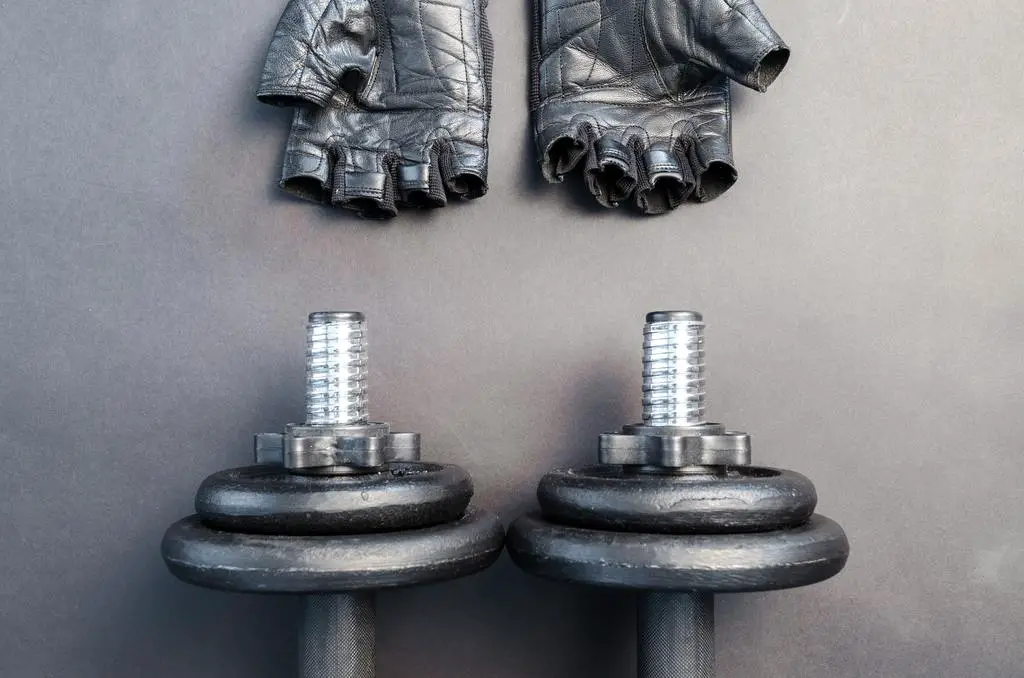 complete_dumbbell_workout_schedule_001 two dumbbells and some gloves for workout