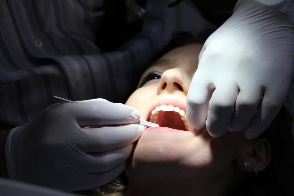how_fitness_impacts_oral_health_003 Woman's face in a dental clinic being checked up by a dentist in gloves