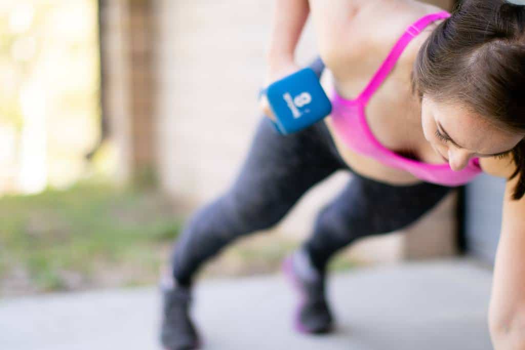 woman-push-up-dumbbell-workout A woman uses a dumbbell to do a push up workout routine