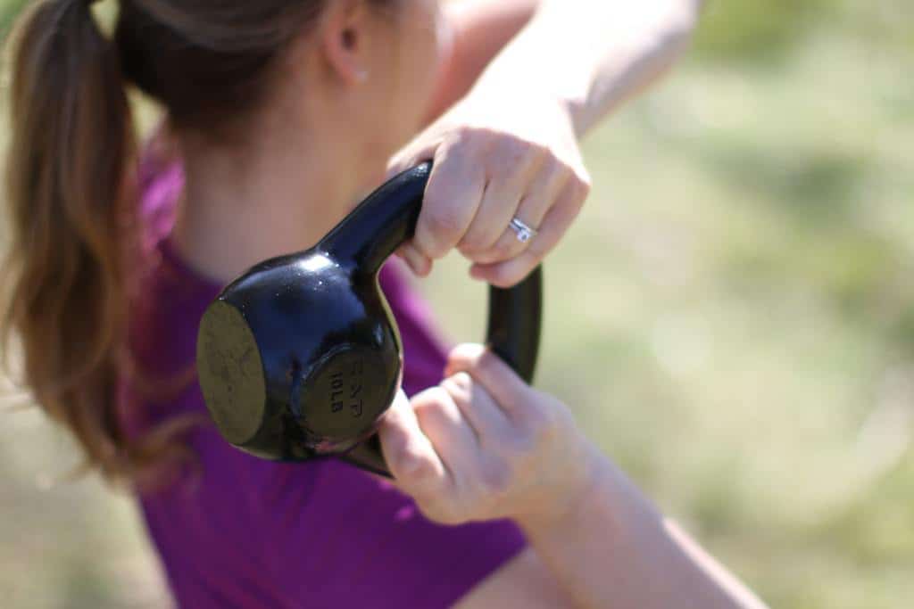 best_kettlebell_050 Woman holds an individual kettlebell during her outdoor workout