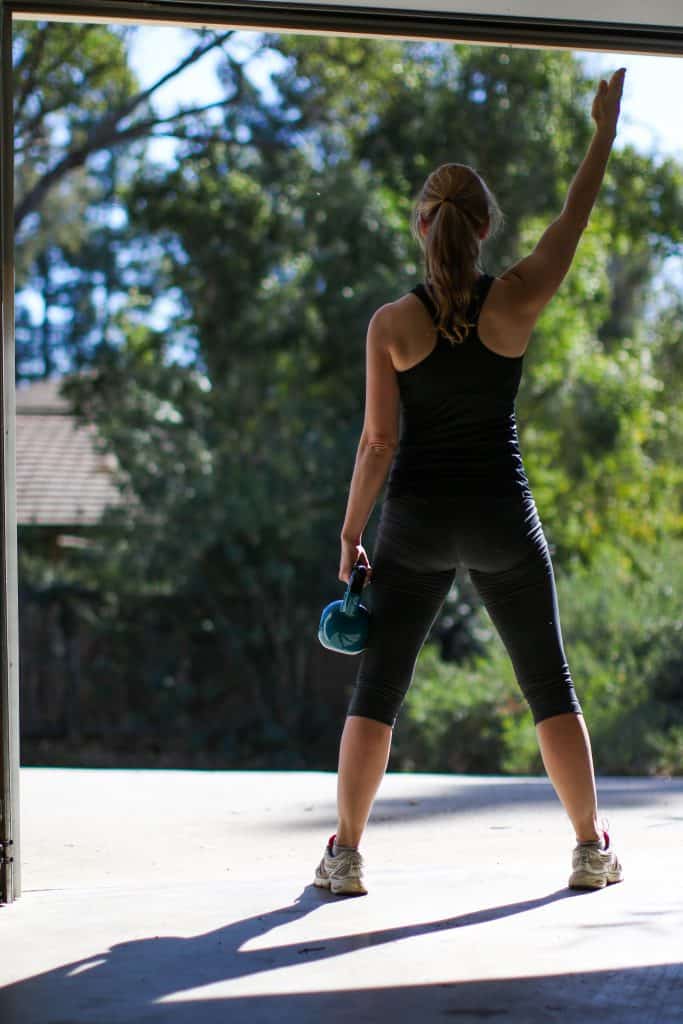 best_kettlebell_059 Woman does kettlebell workout in home gym in her garage
