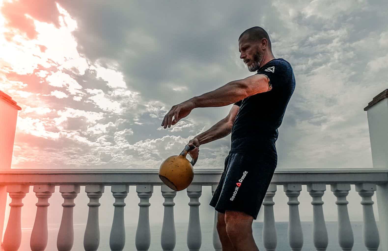 Man swinging a kettlebell with only one hand