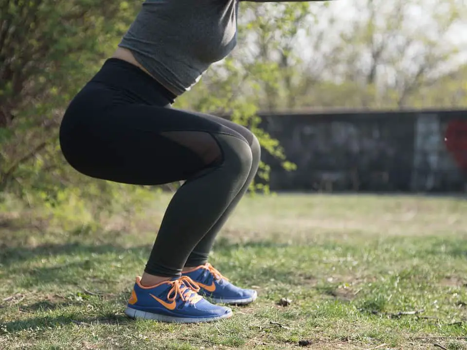 Woman doing squats outdoors