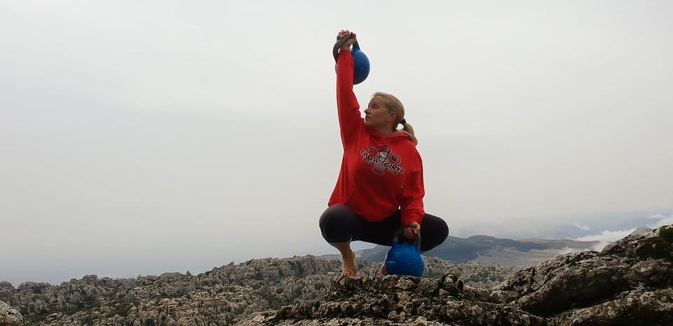 Woman lifting a kettlebell with her right hand