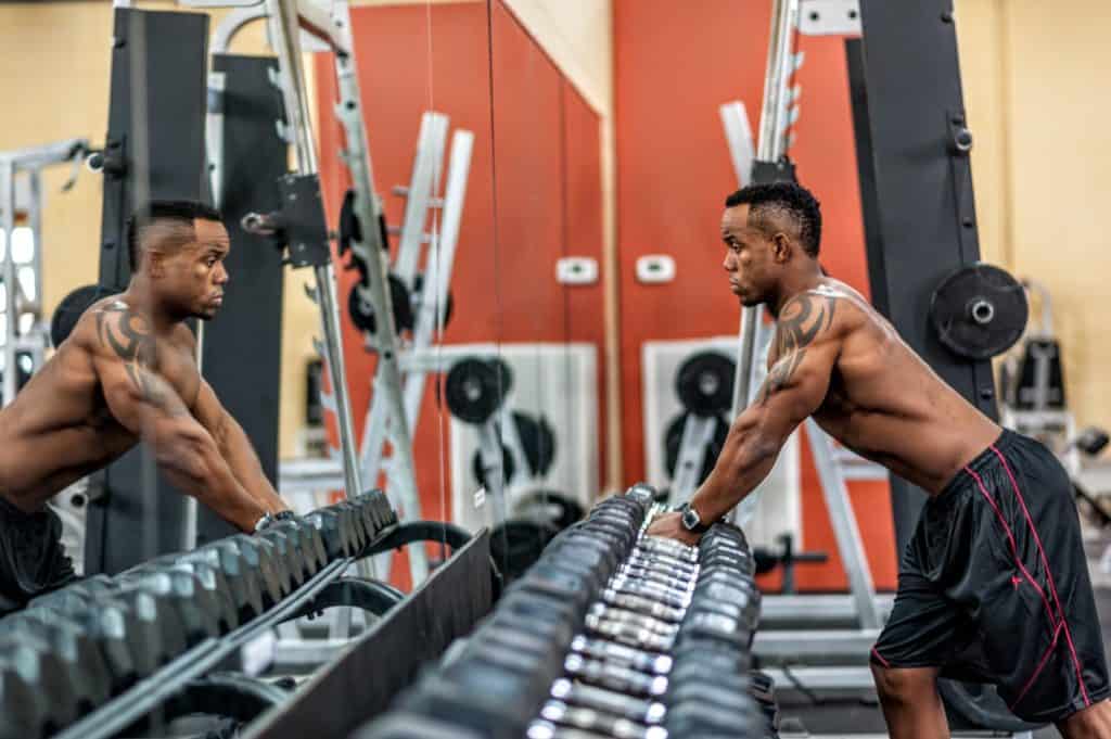Man picking up dumbbells from rack