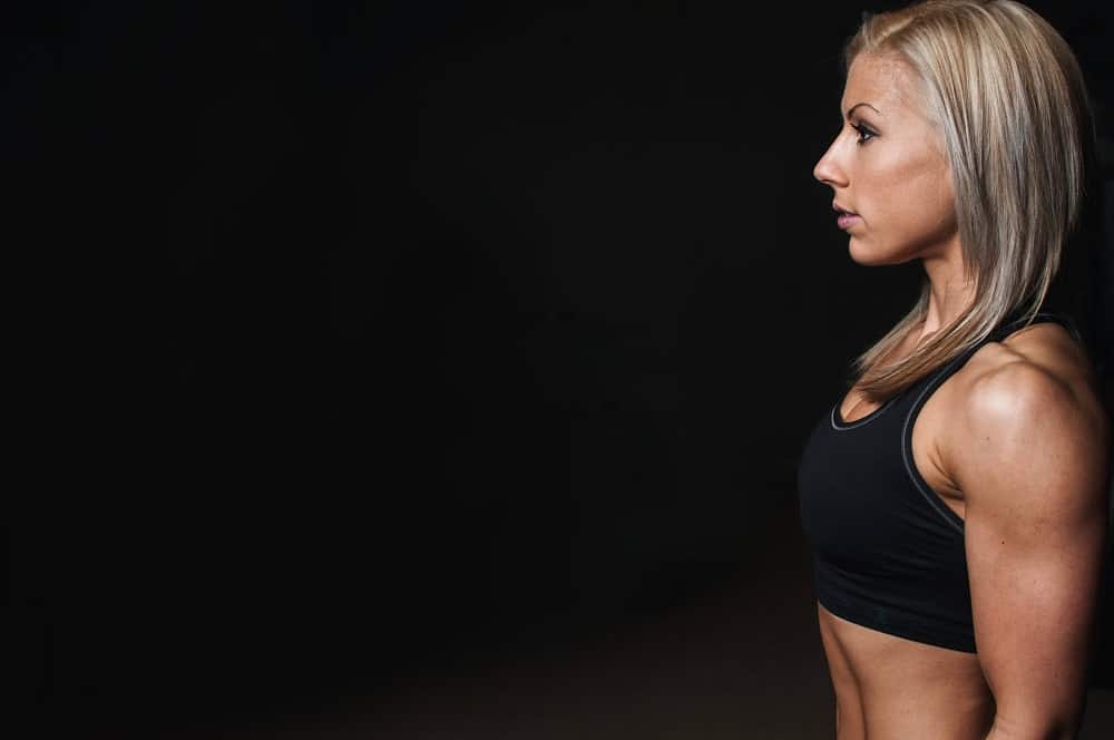 Woman standing sideways while wearing a black sports bra