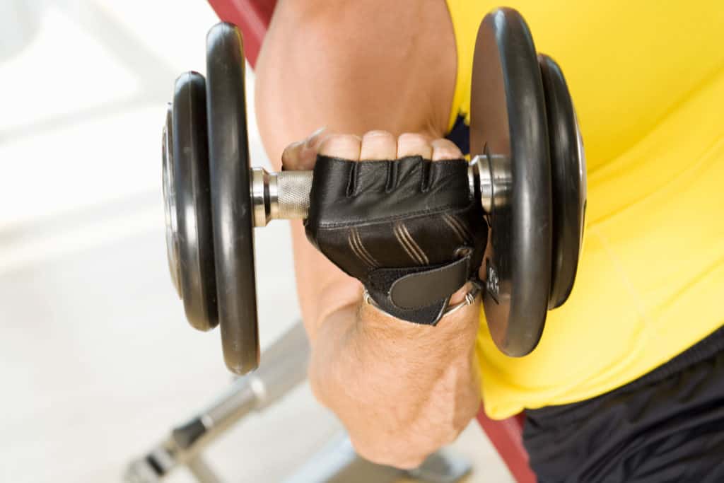 Man showing how do adjustable dumbbells work by lifting it with his hands