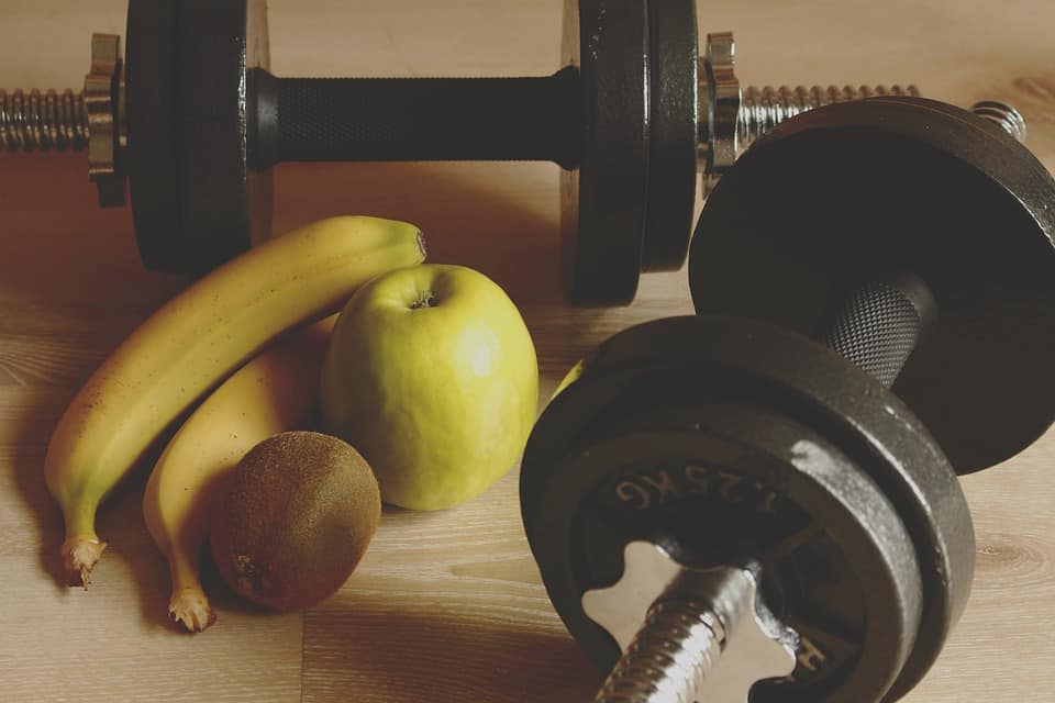 Fruits and dumbbells laying on the floor