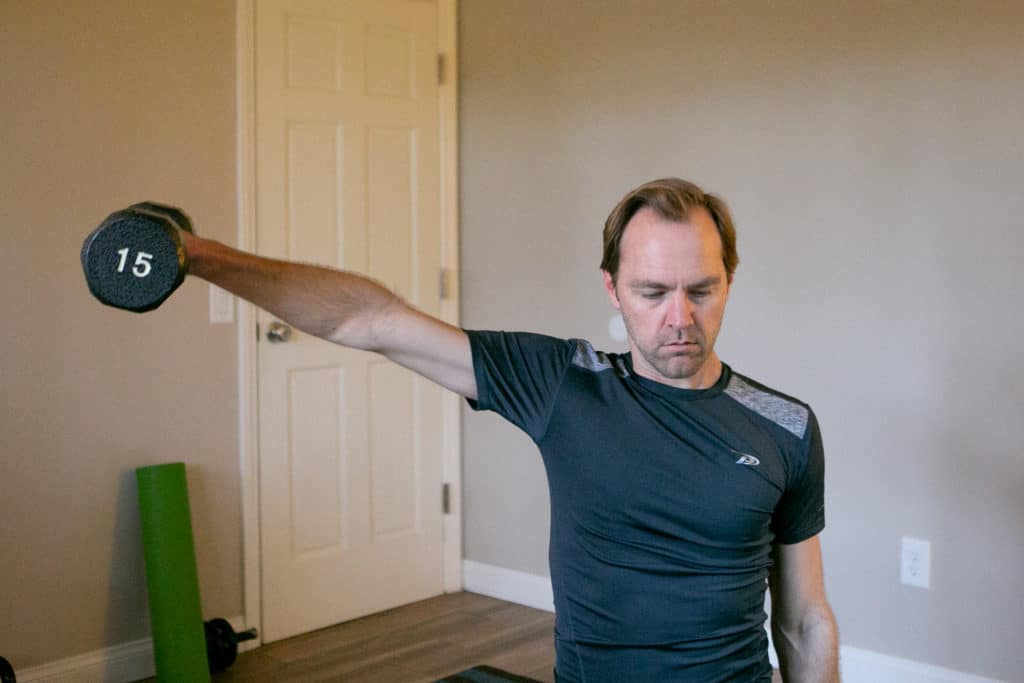 Man lifting a dumbbell above his shoulders