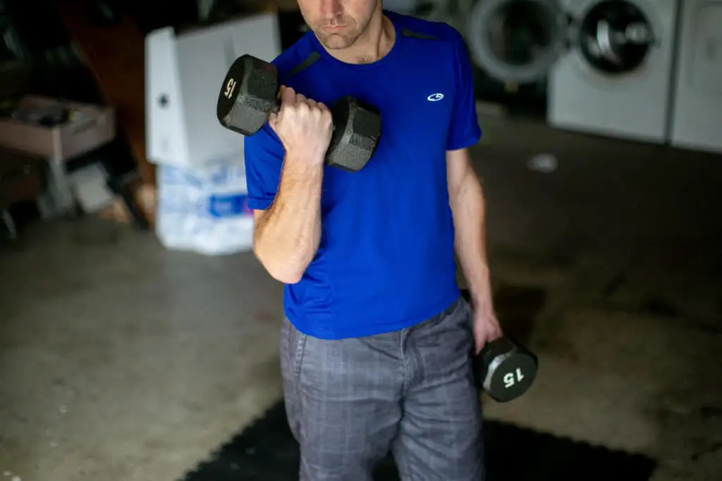 Man lifting dumbbells in his garage
