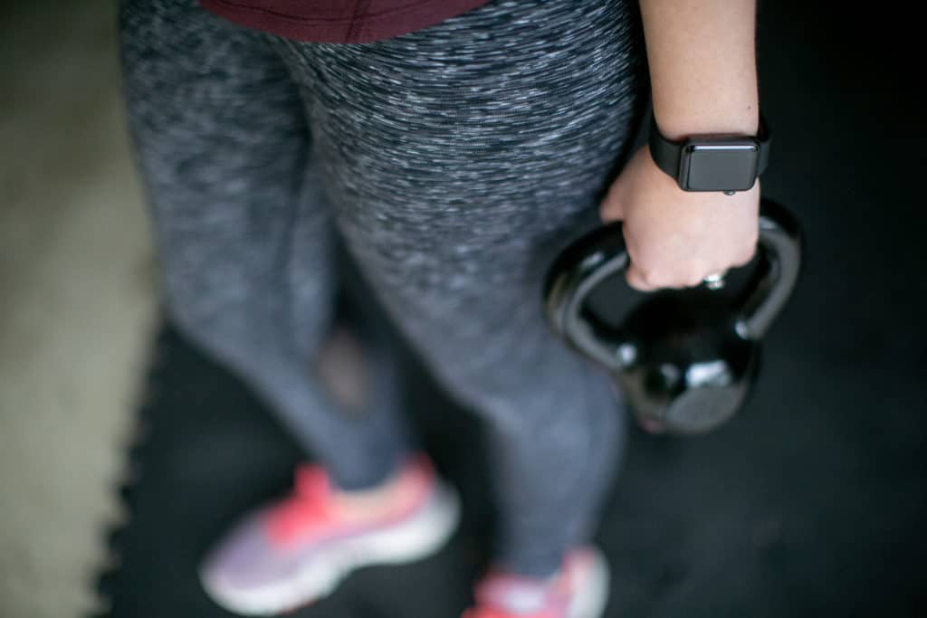 A person wearing a fitness tracker for kettlebell workout