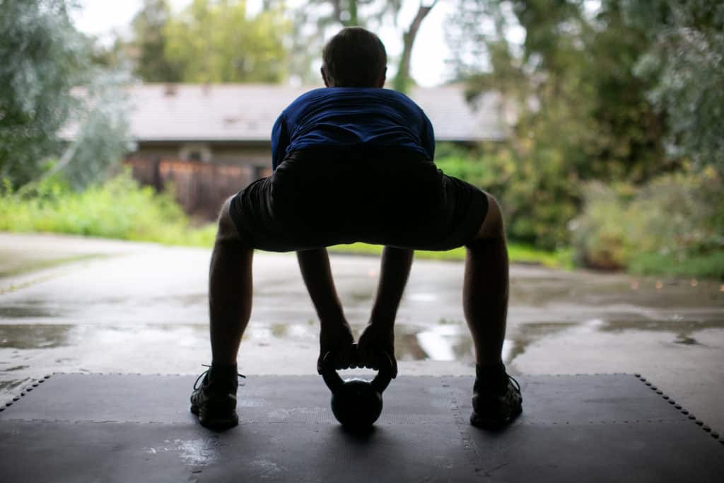 Man trying to lift a kettlebell from the floor