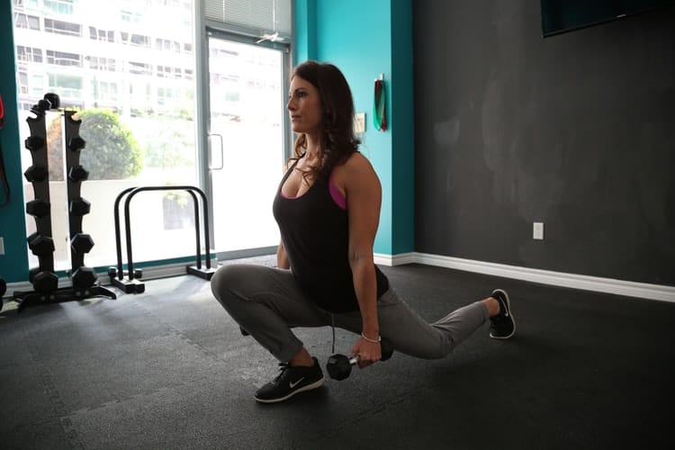 Woman performing quad exercises with dumbbells