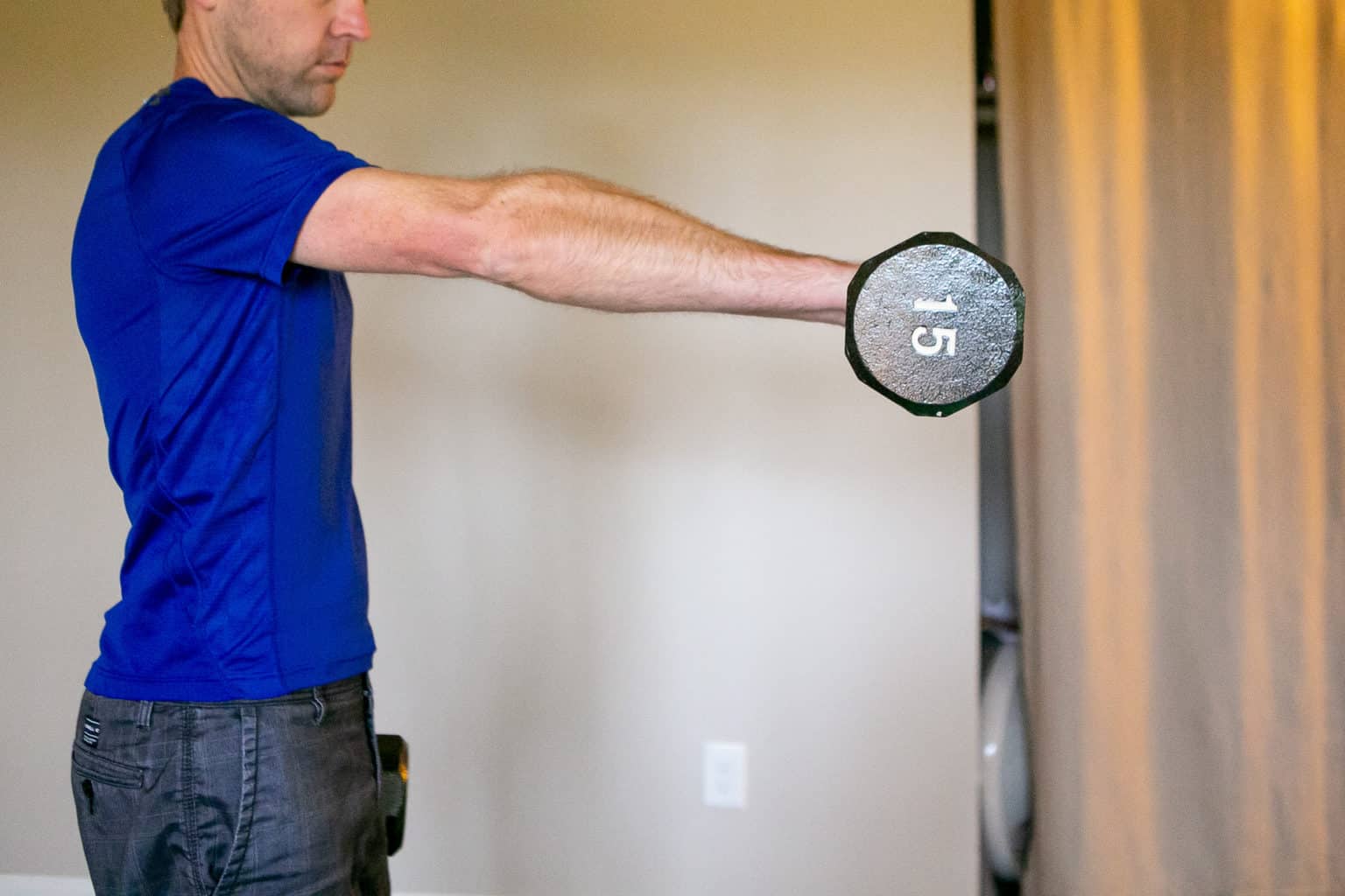 Man holding a pair of dumbbells while performing dumbbell exercises