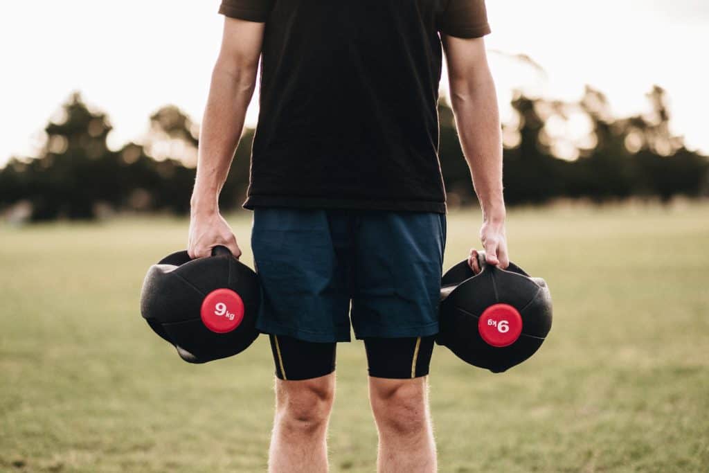 Man holding a pair of 9 kg adjustable dumbbells