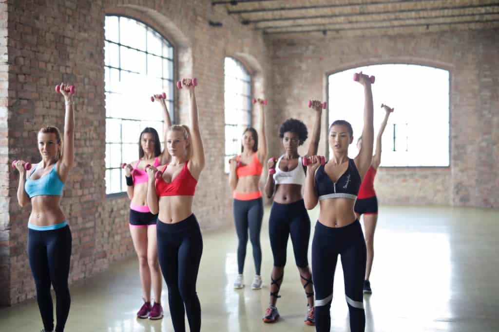 Group of women performing dumbbell exercises and reps