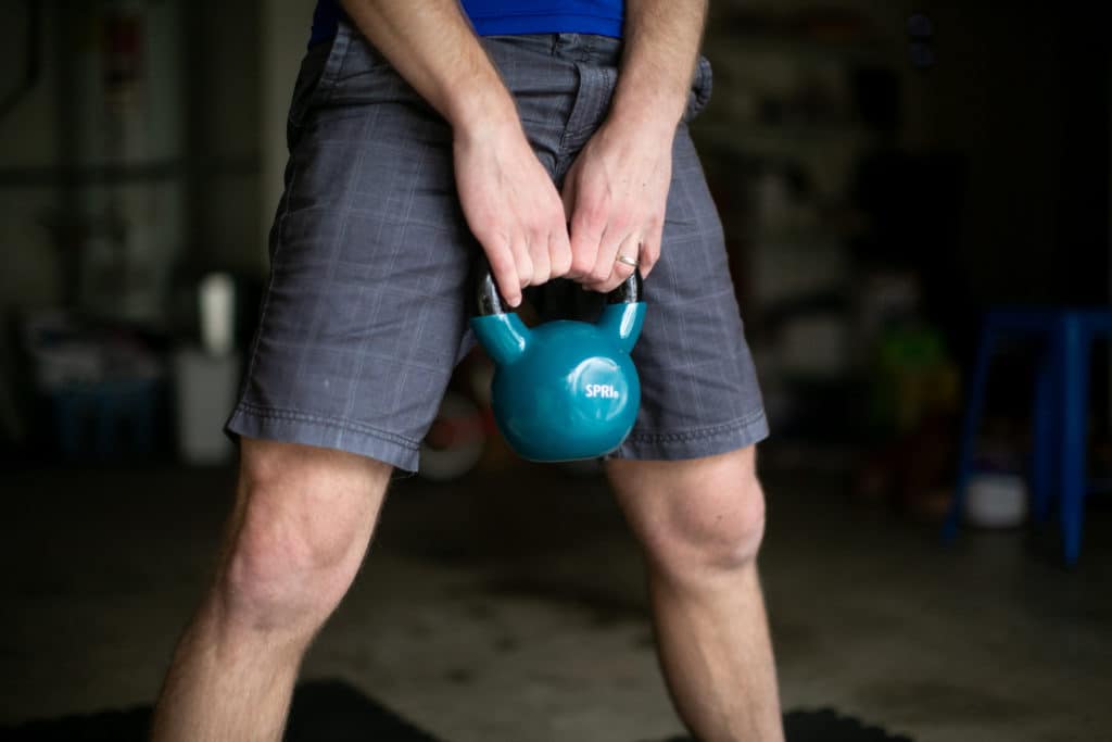 Man holding a kettlebell with both hands