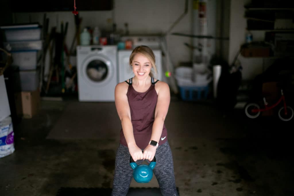 Woman swinging a kettlebell away from her body