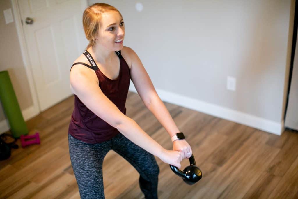 Woman trying to swing a kettlebell with both hands