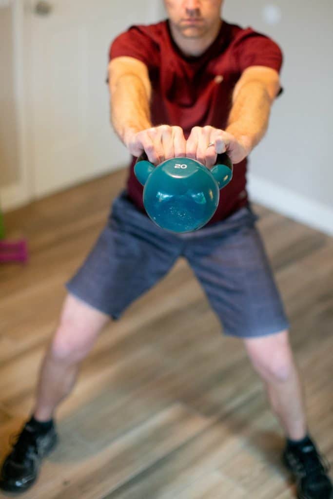 Man trying to swing a kettlebell with both hands