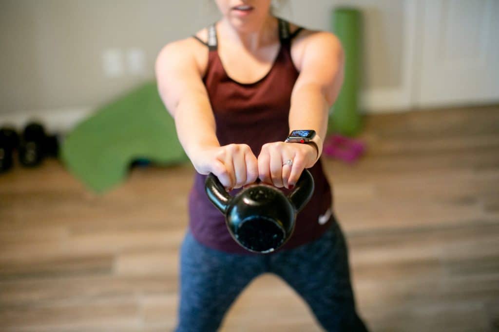 Woman trying to swing a kettlebell with both hands