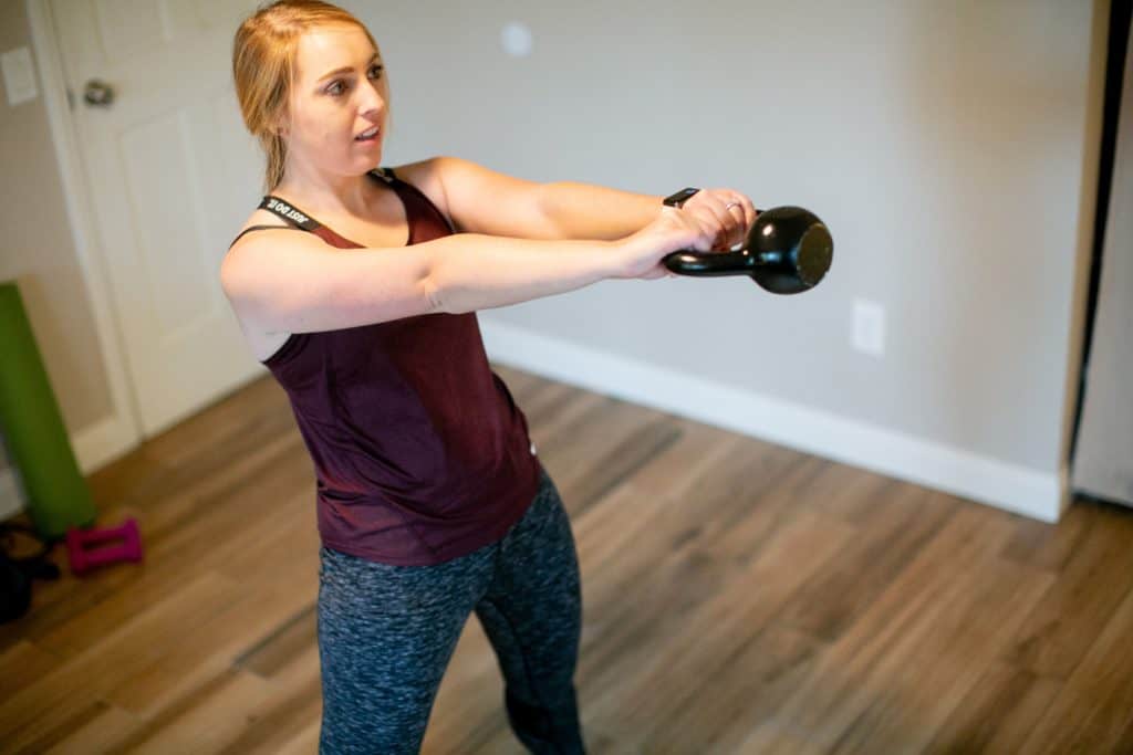 Woman trying to swing a kettlebell with both hands