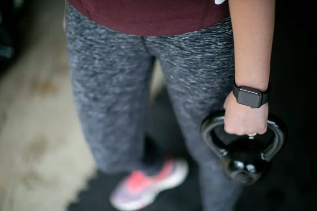 Person wearing a fitness tracker for kettlebell workout