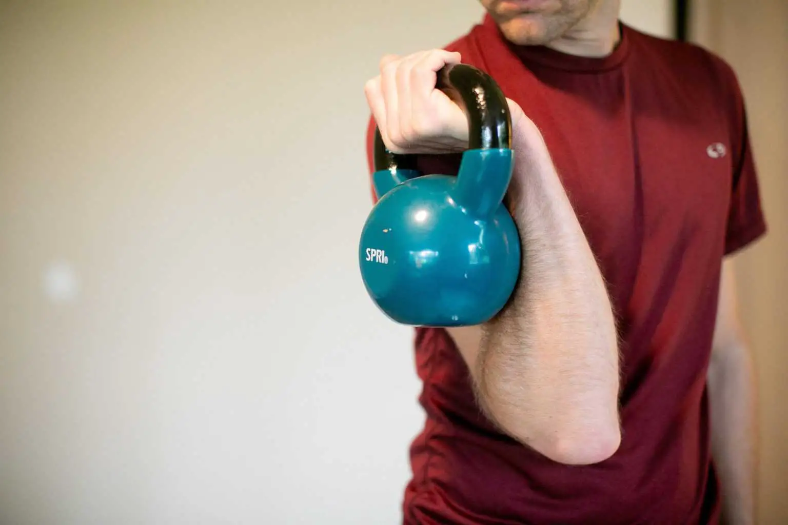 Man holding a kettlebell with one hand