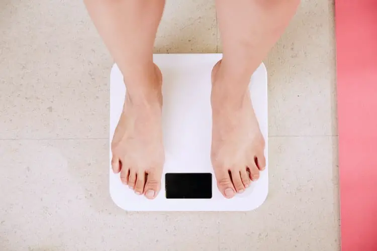 Person weighing himself on a scale