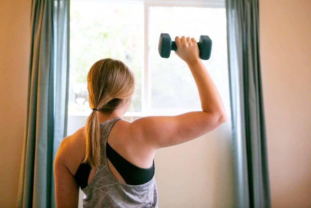 Back view of a woman holding a 2kg dumbbell with one hand