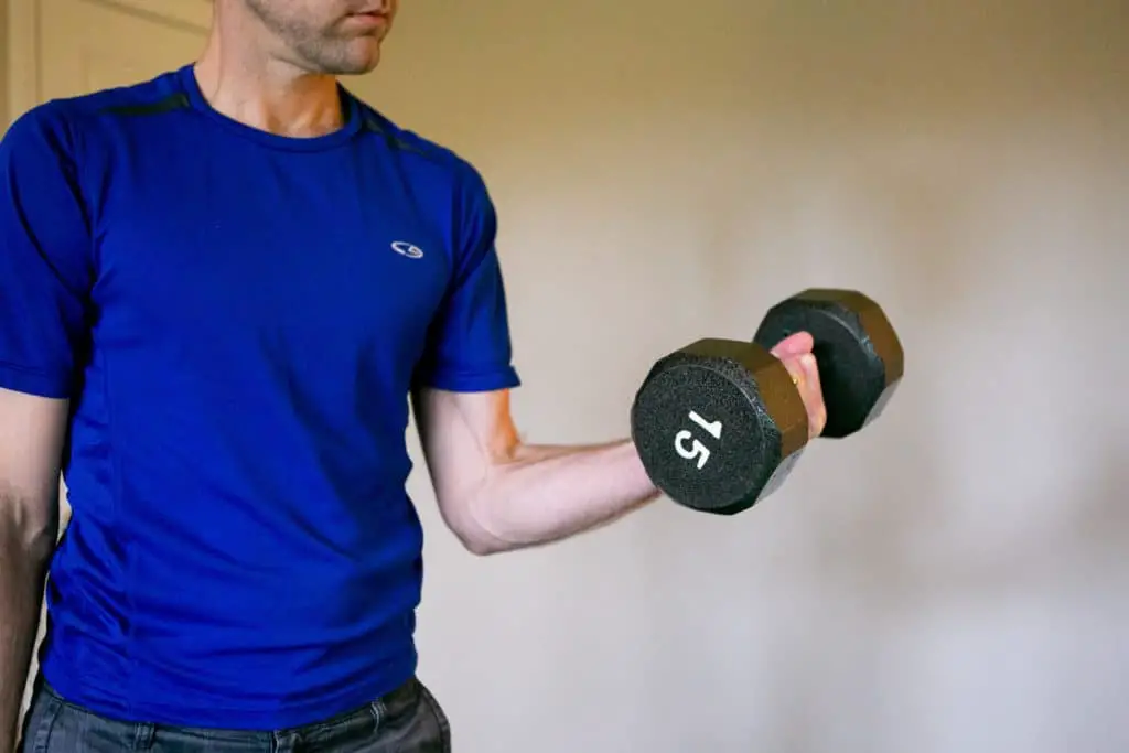 Man lifting a 15kg dumbbell with one hand