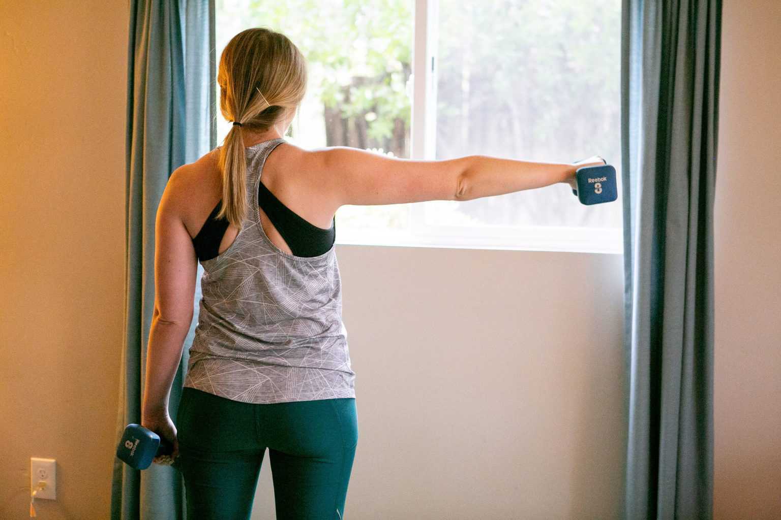 Woman doing a trap workout with dumbbells