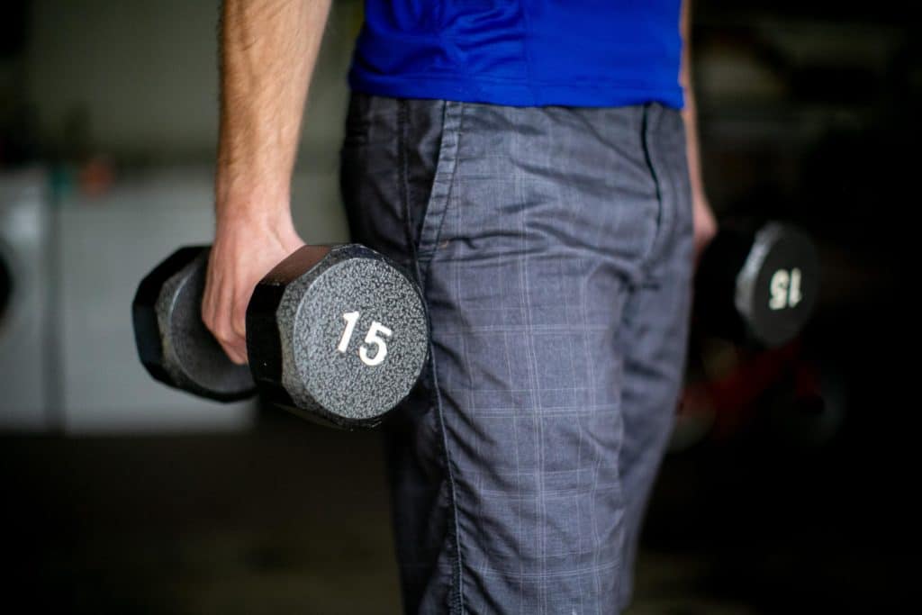 Man holding a pair of 15kg dumbbells in each hand