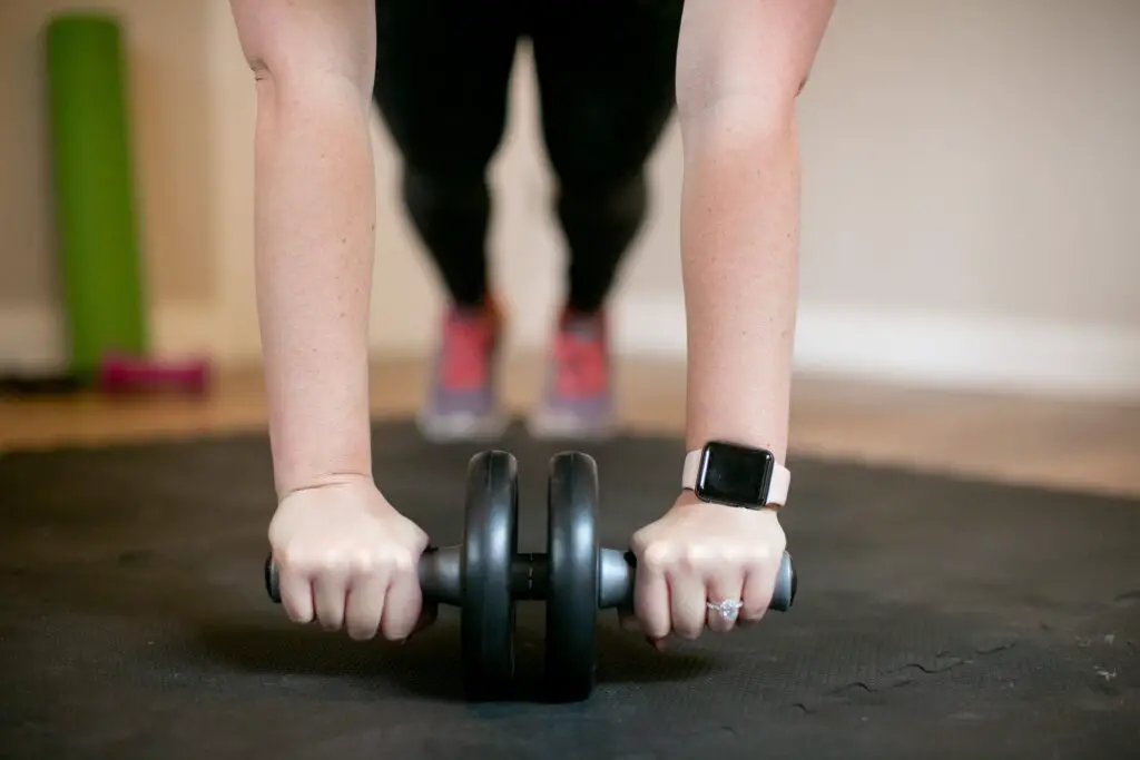 Woman wearing a ring and watch while using an ab roller