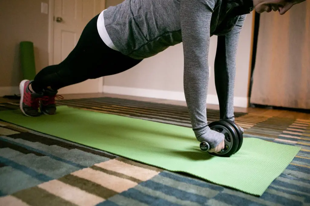 Woman using an ab roller trying to reduce her belly fat