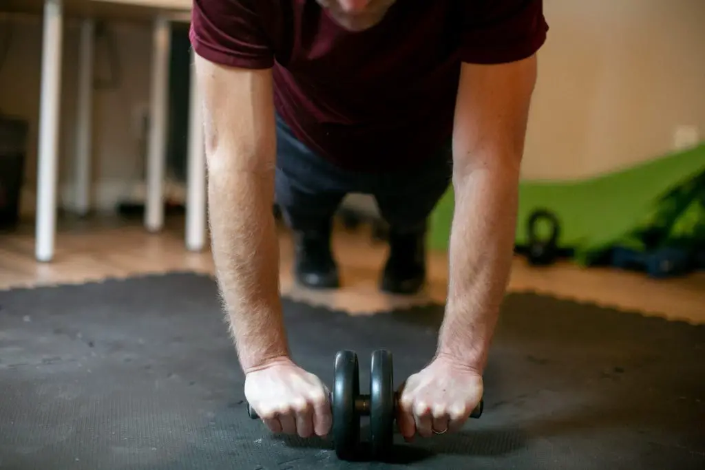 Man using an ab roller on his home gym