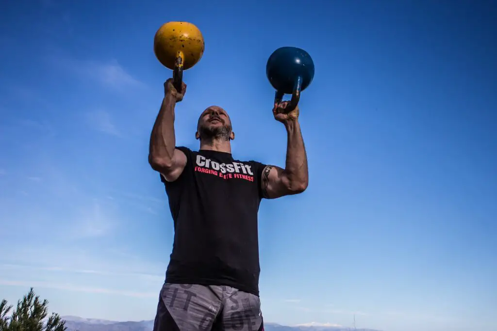 Man lifting a kettlebell in each hand