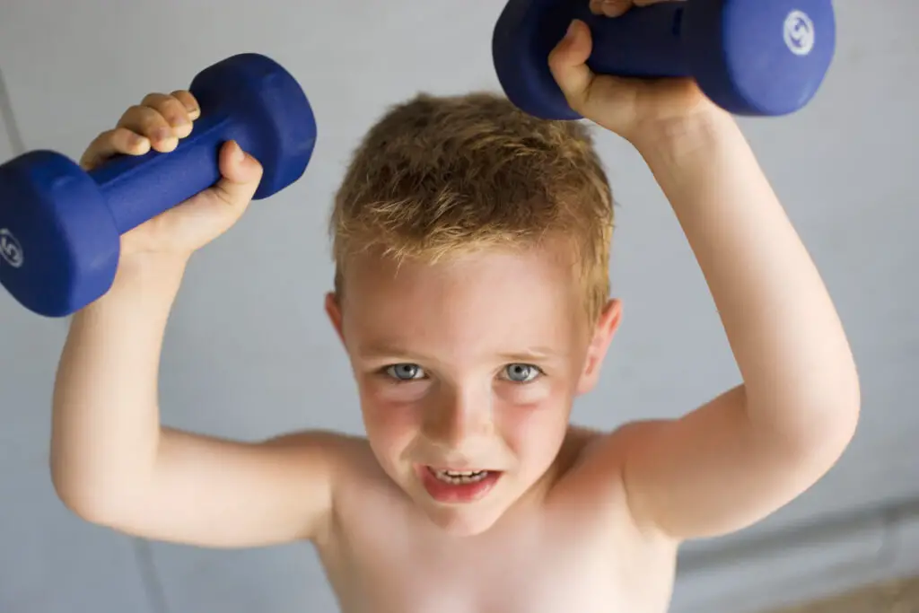 Boy lifting dumbbells wondering if it will stop his height growth