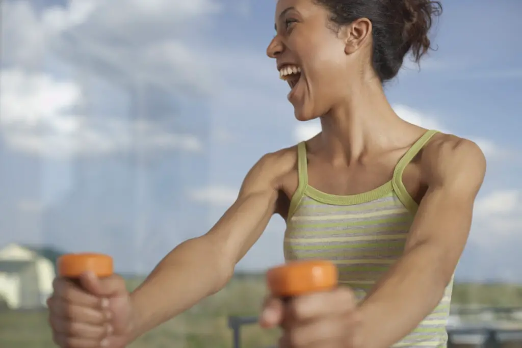 Woman working out using dumbbells to gain muscle