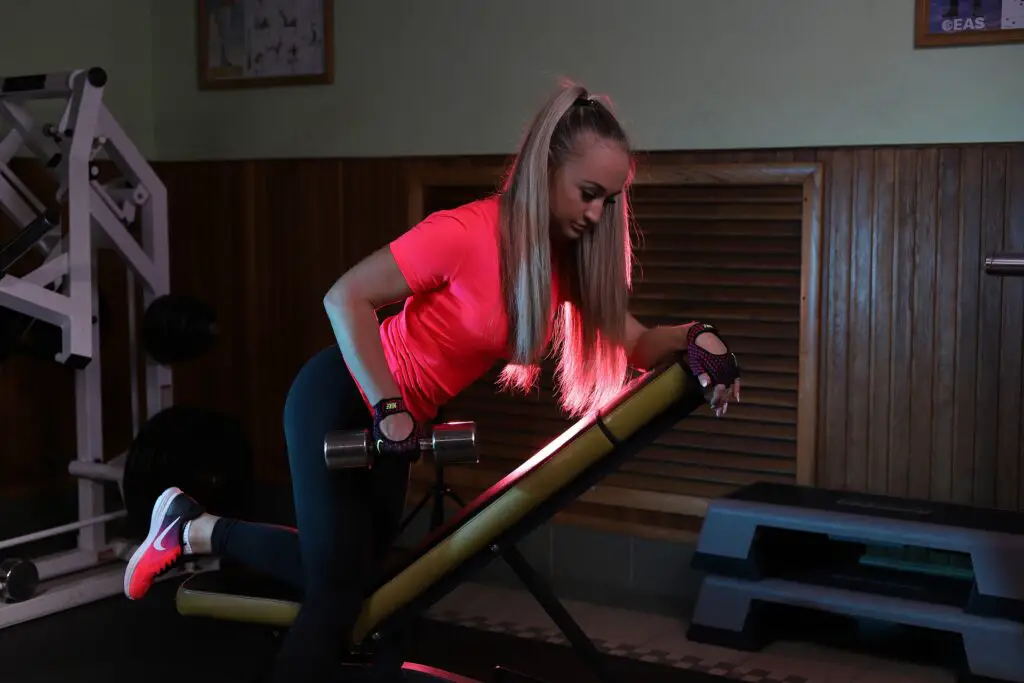 Woman using a bench while doing dumbbell exercises
