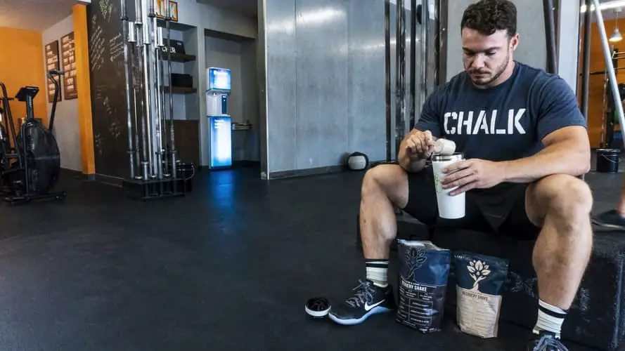 Man sitting down pouring his supplement stack to get ripped