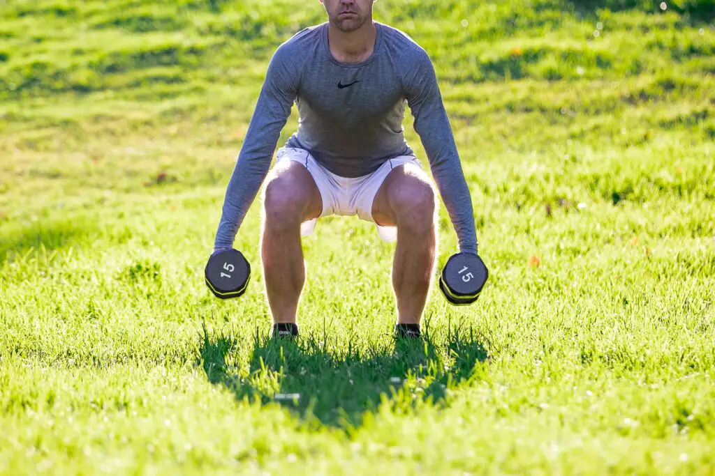 Man trying to lift dumbbells with each hands