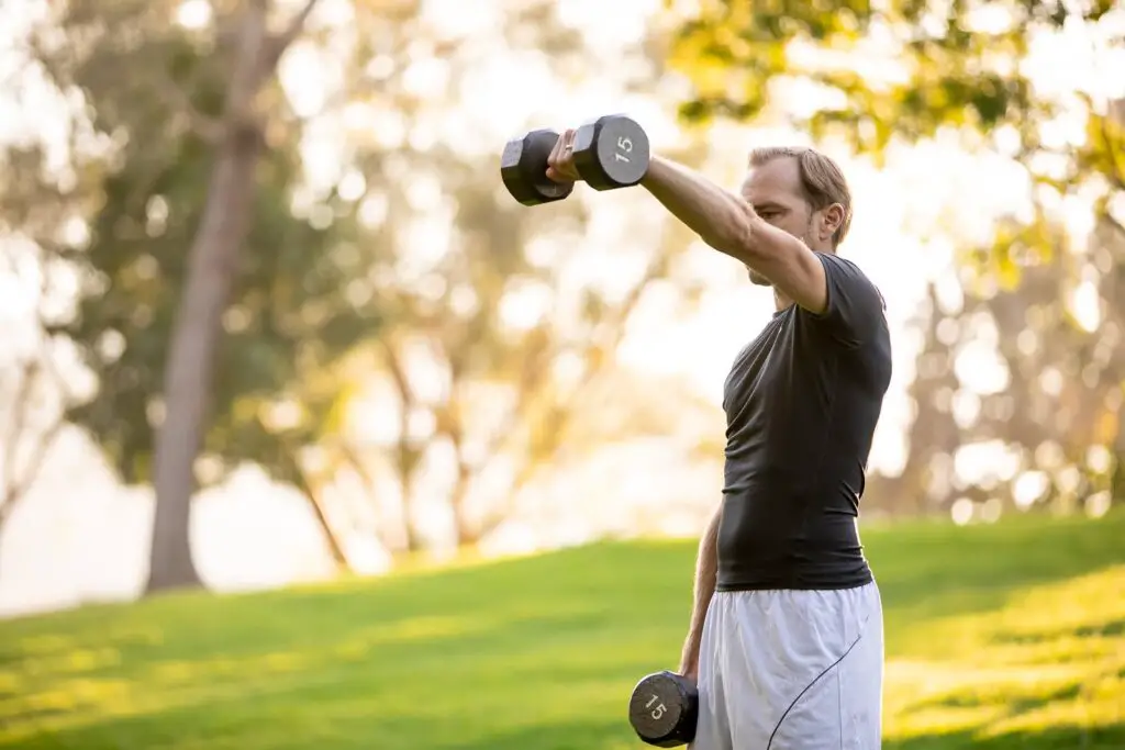 Man lifting a dumbbell with one arm while holding the other pair on his side
