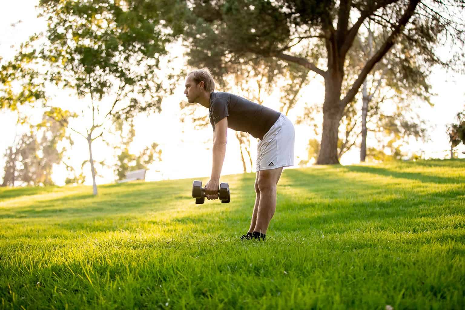 Man trying to lift dumbbells with each hands