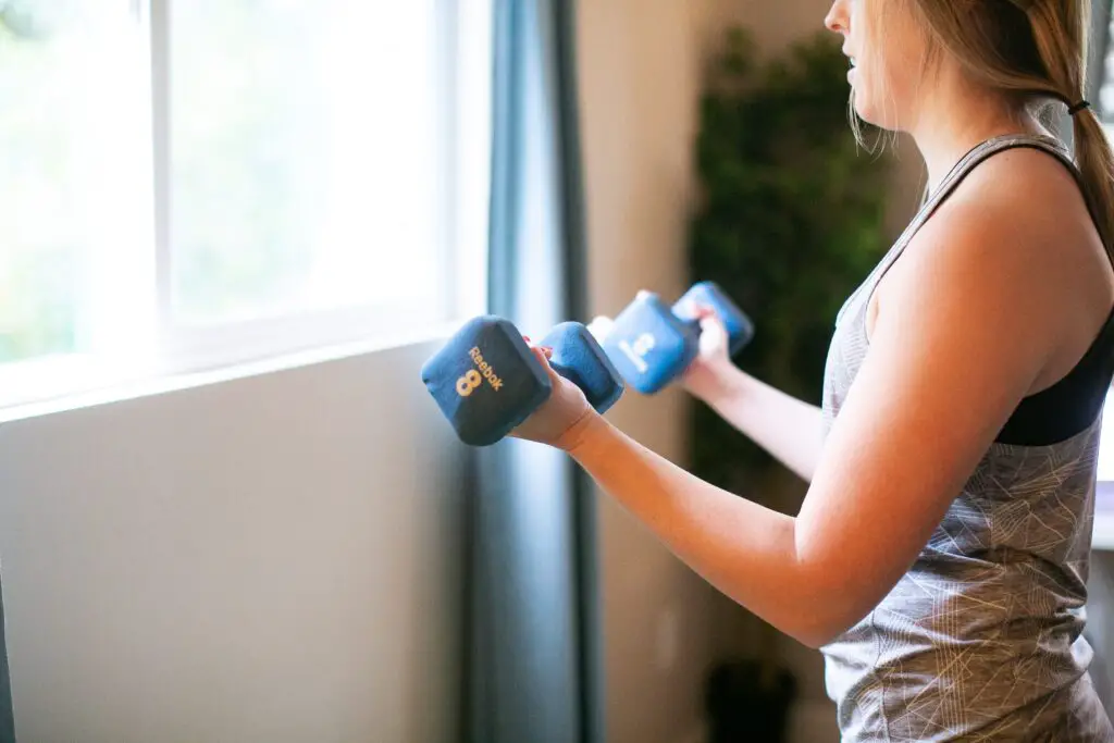 Woman holding a pair of dumbbells at chest level