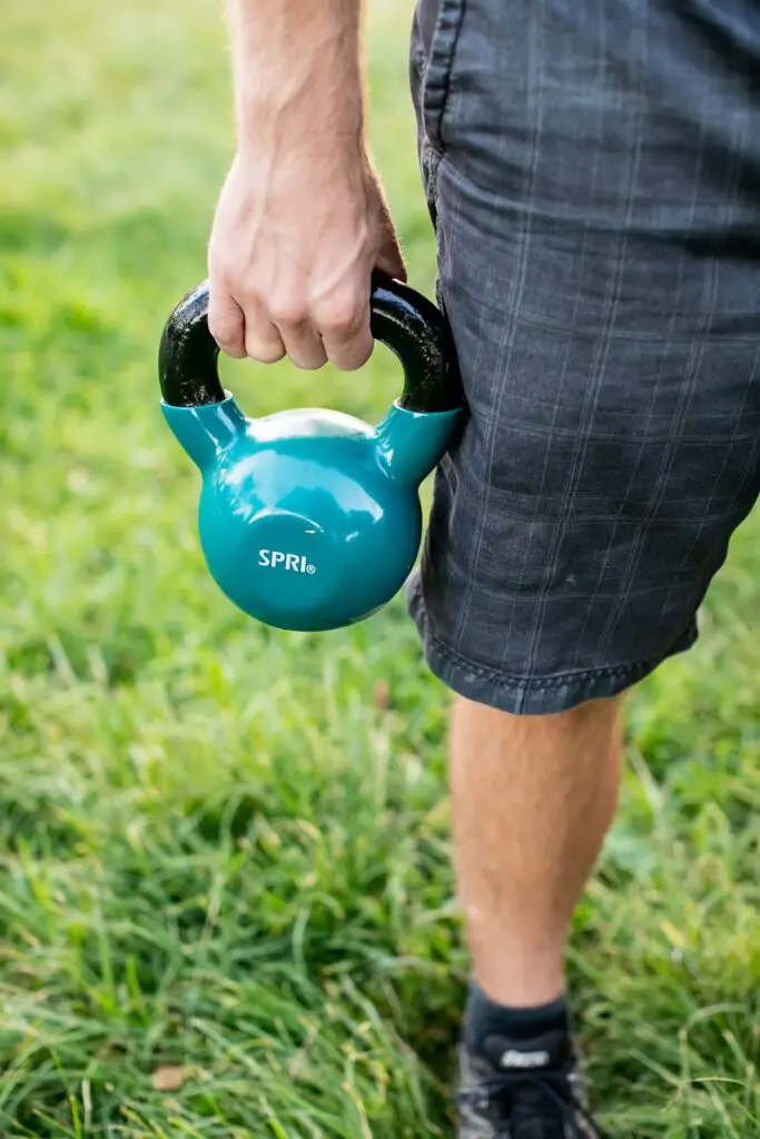 Person holding a kettlebell with one hand