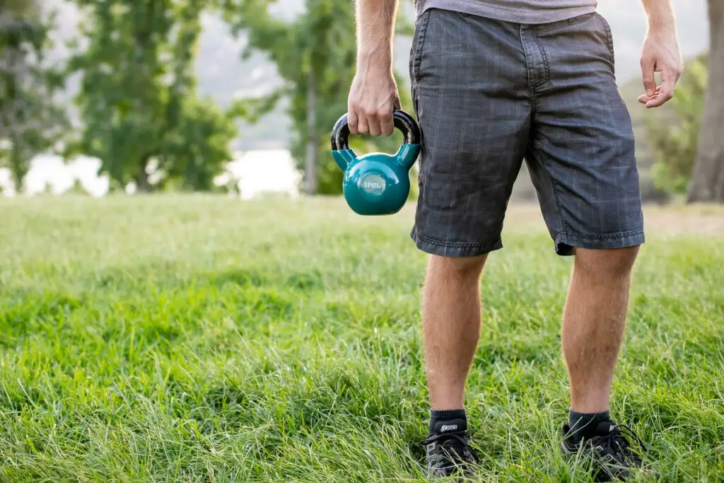 Person holding a kettlebell with one hand