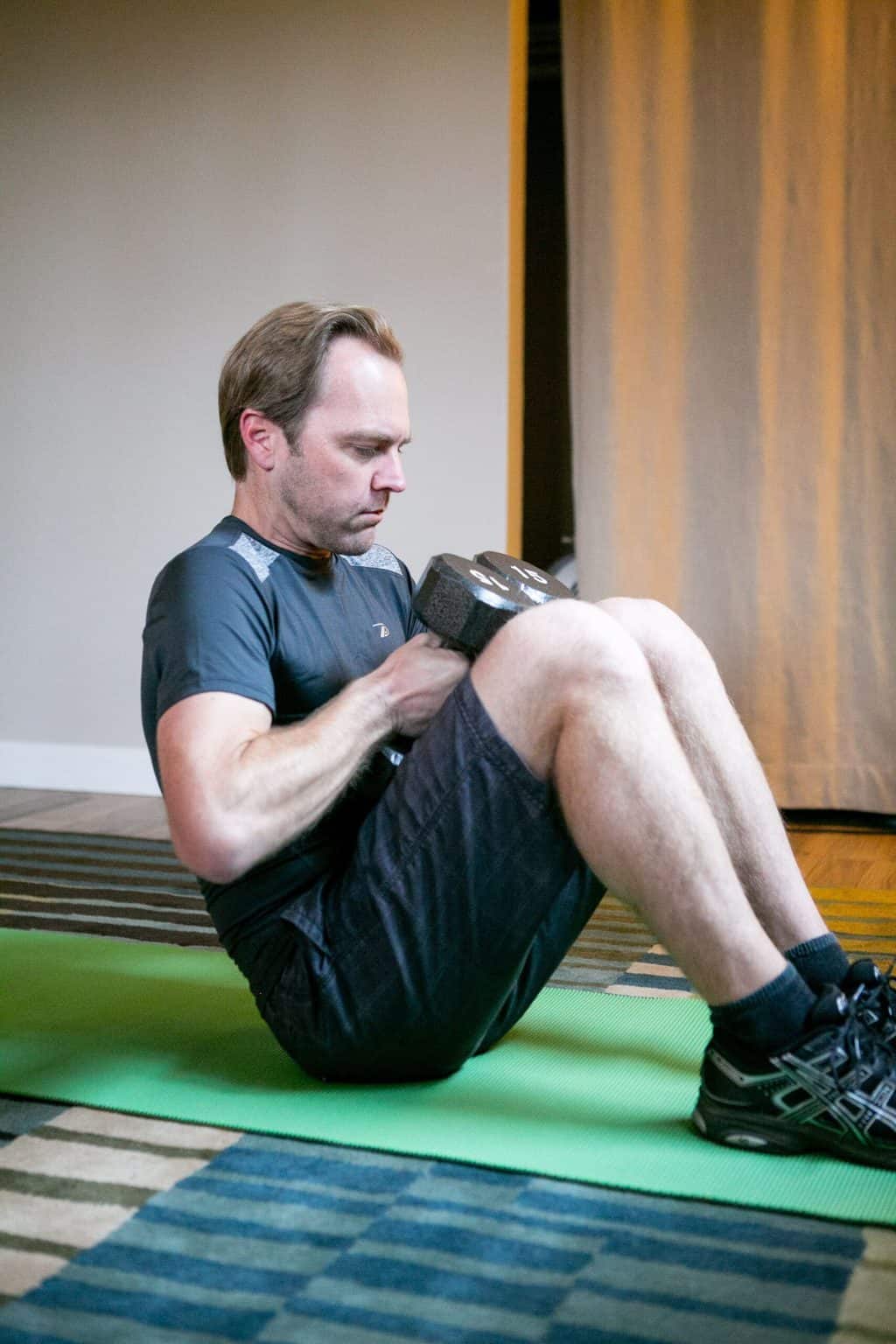 Man doing dumbbell crunch exercises