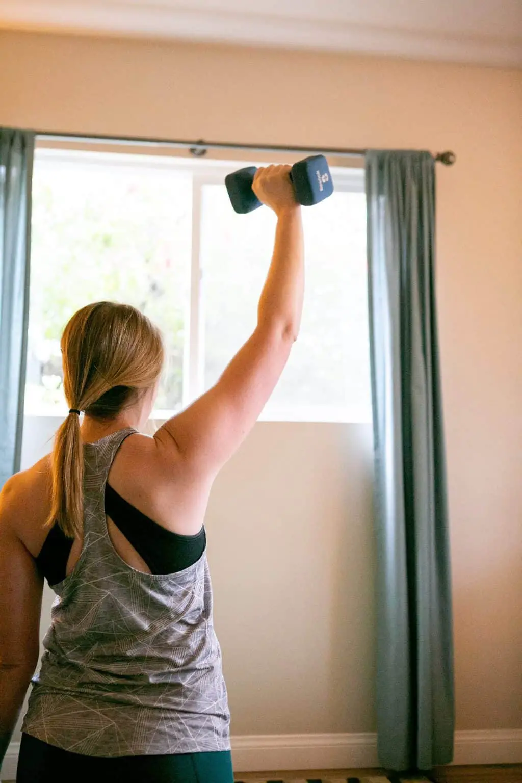A woman lifting a dumbbell with one hand